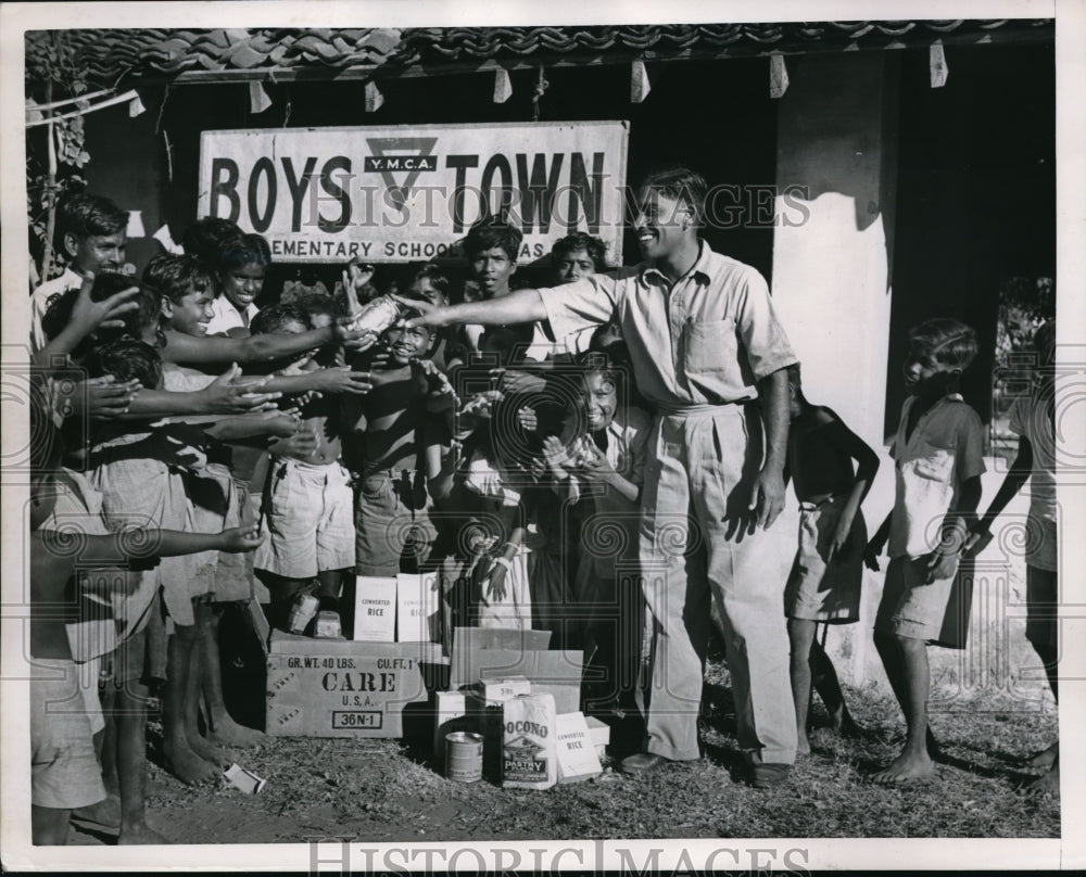 1951 Press Photo Palackel Chacko Mathew passing out food packages. - Historic Images