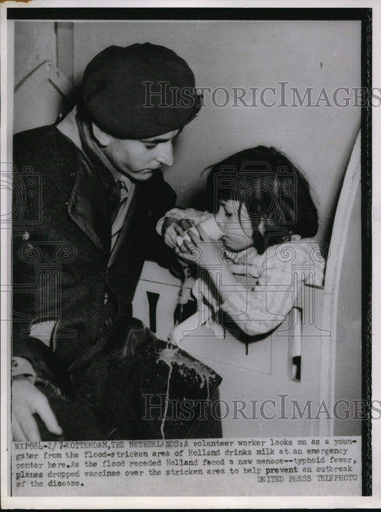 1953 Press Photo A volunteer feeds a youngster at an emergency center in Holland - Historic Images