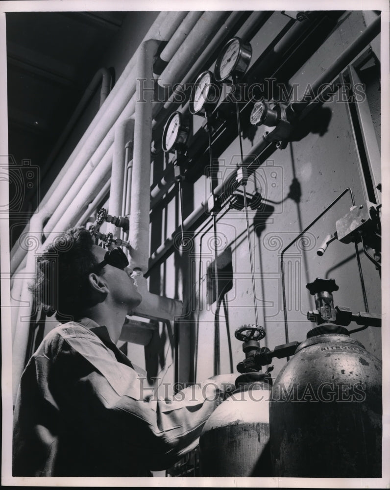 1949 Press Photo B.F Goodrich Researcher through a peephole to watch experiment behind the barrica - Historic Images