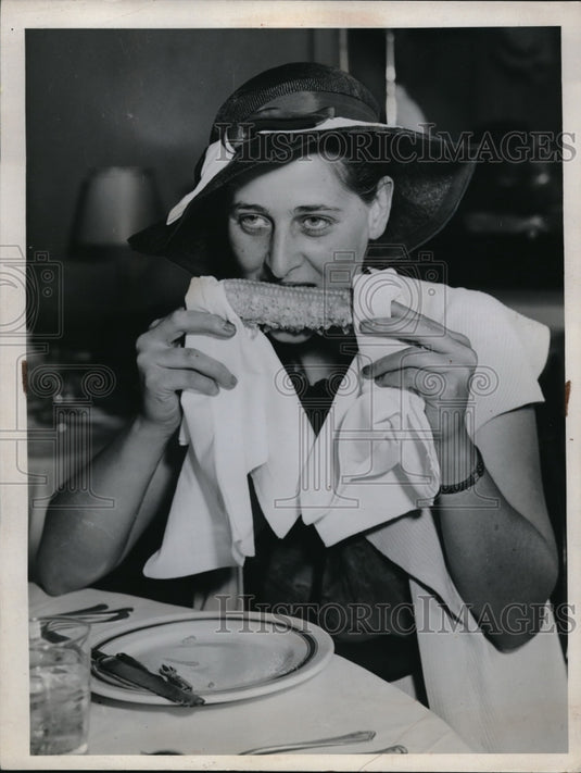 1935 Woman wearing hat eating corn  - Historic Images