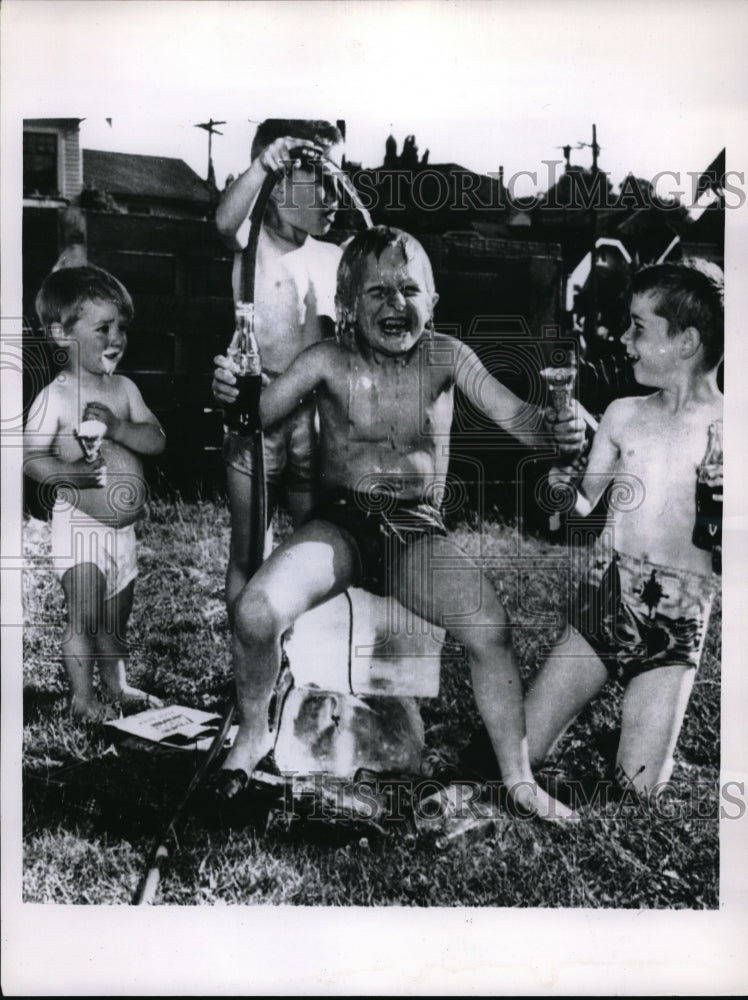 1955 Seattle boys conquer heat wave by squirting water from hose - Historic Images