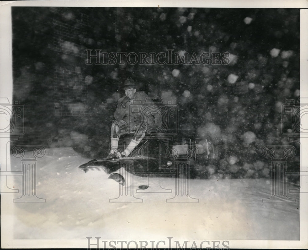 1940 Press Photo A Boston motorist sits on top of his car while he figures out how to get out of the - Historic Images