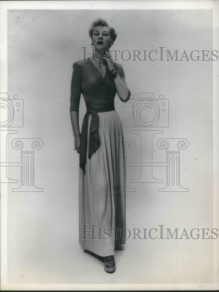 1950 Press Photo Model poses in a classy rayon jersey wrap top and pleated skirt - Historic Images