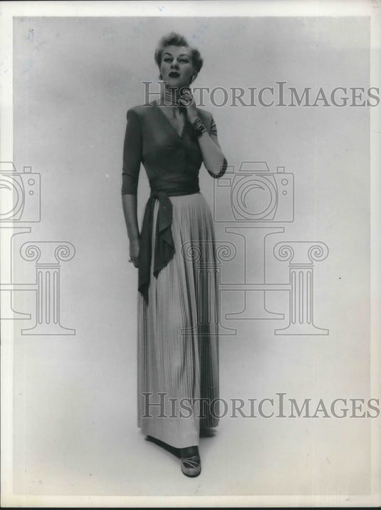 1950 Press Photo Model poses in a classy rayon jersey wrap top and pleated skirt - Historic Images