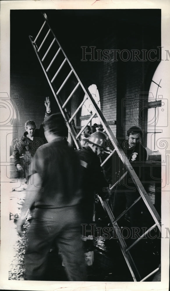 1985 Press Photo Cleveland Ohio Firemen lower ladder into water filled  shaft - Historic Images