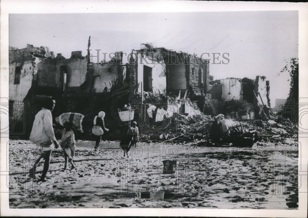 1955 Residents of Kena plod through mud after disastrous rains - Historic Images