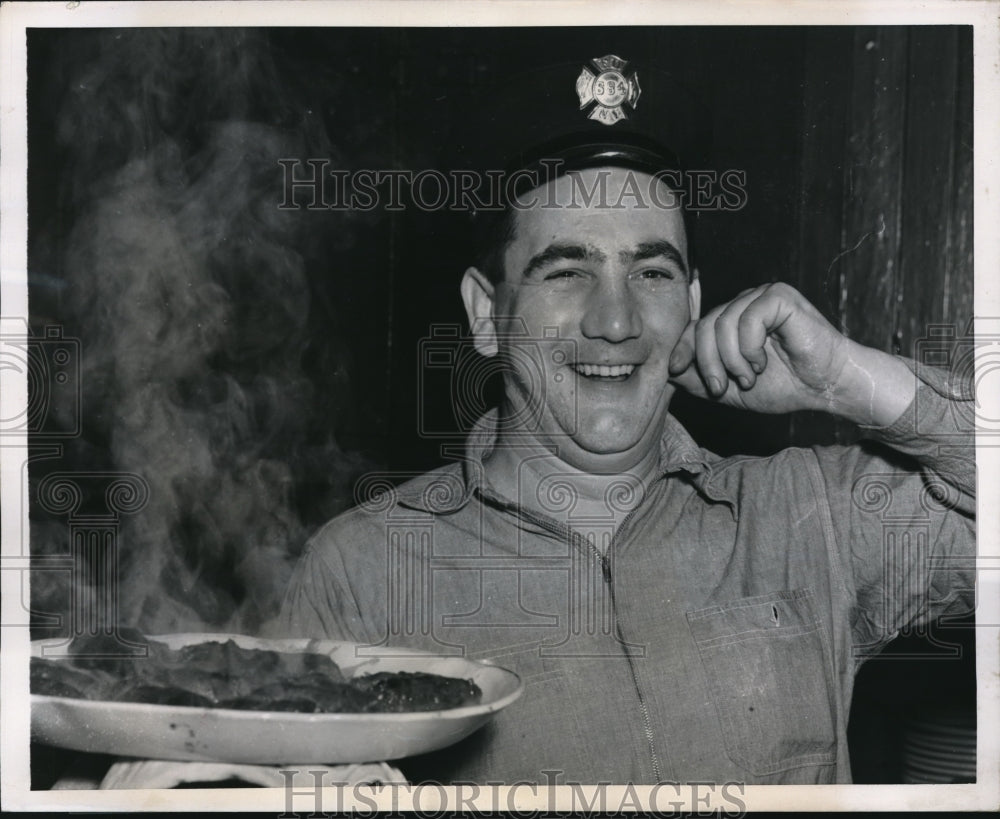 In New York,Fireman William McCrea seems satisfied with his cooking - Historic Images