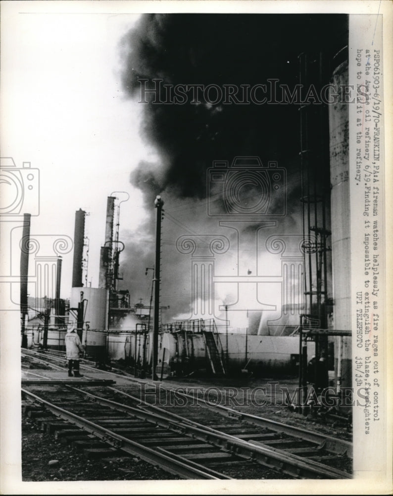 1970 Press Photo Fireman watches helplessly at fire in Amelie oil refinery - Historic Images