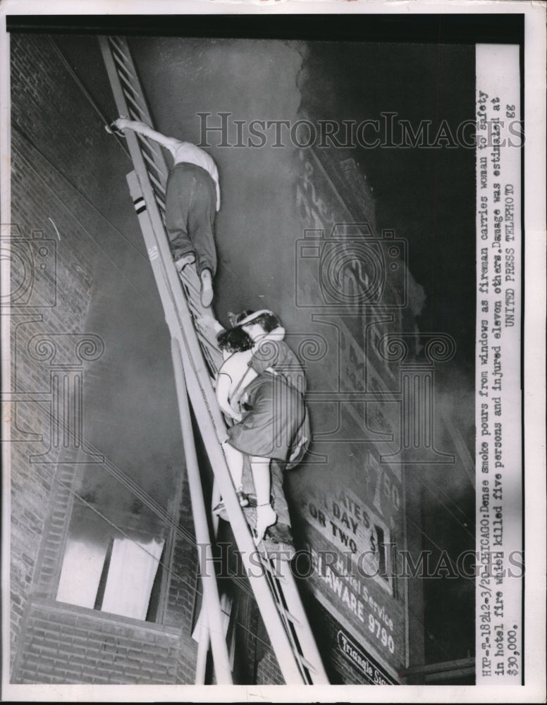 1953 Press Photo Chicago Hotel fire, fireman carries woman to safety - Historic Images