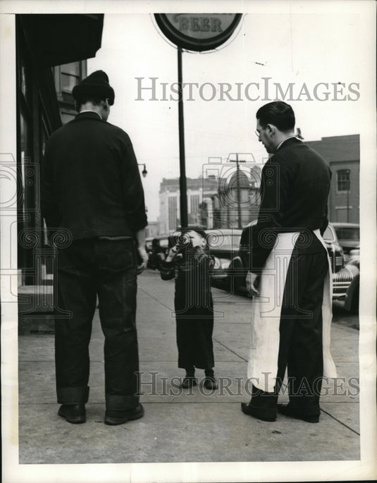 1941 Press Photo A young boy serenades local grocer & gets some lollipops-Historic Images