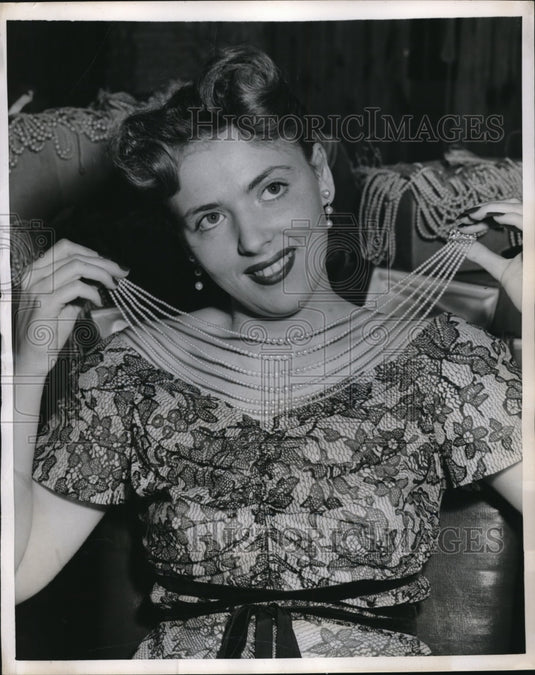 1951 Press Photo Artificial pearl necklace tried on by a woman-Historic Images