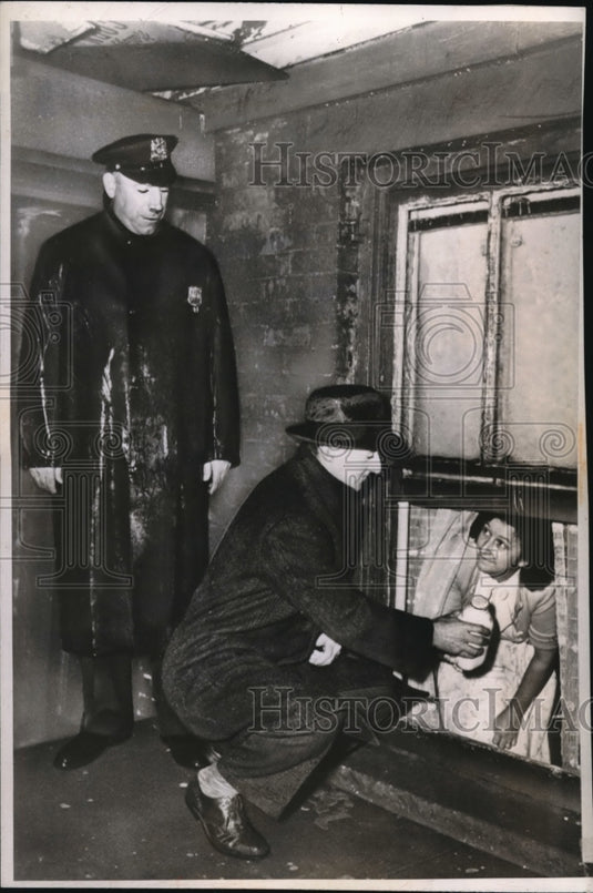 1947 Press Photo Refusing to leave her condemned home, a wife is handed milk. - Historic Images