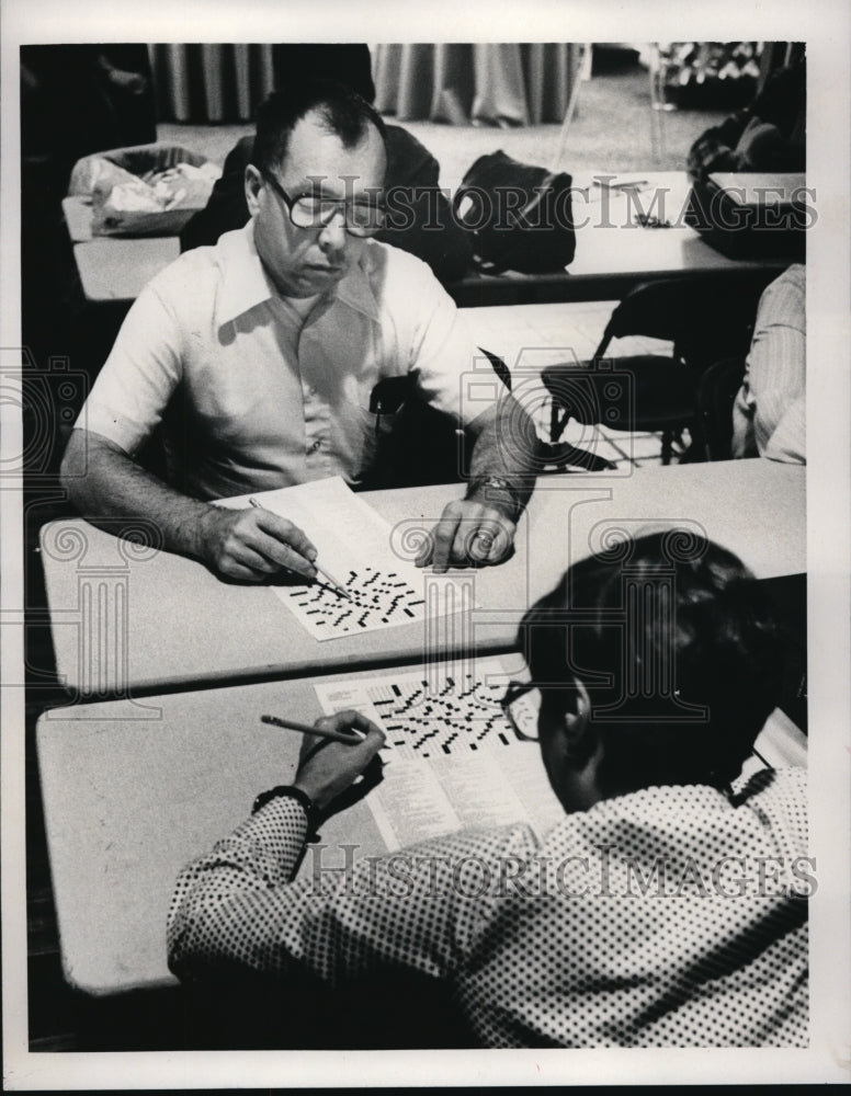 Press Photo Two people working on crossword puzzles. - Historic Images