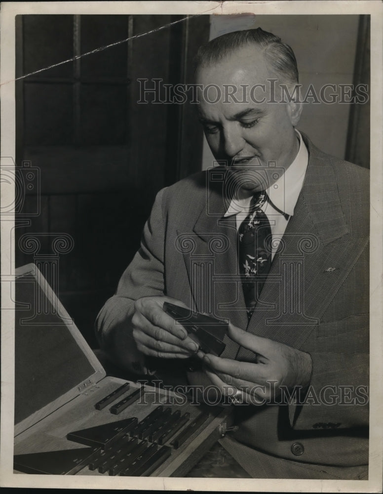 Press Photo Gage Webber of Webber Gage Company looking at blocks - Historic Images