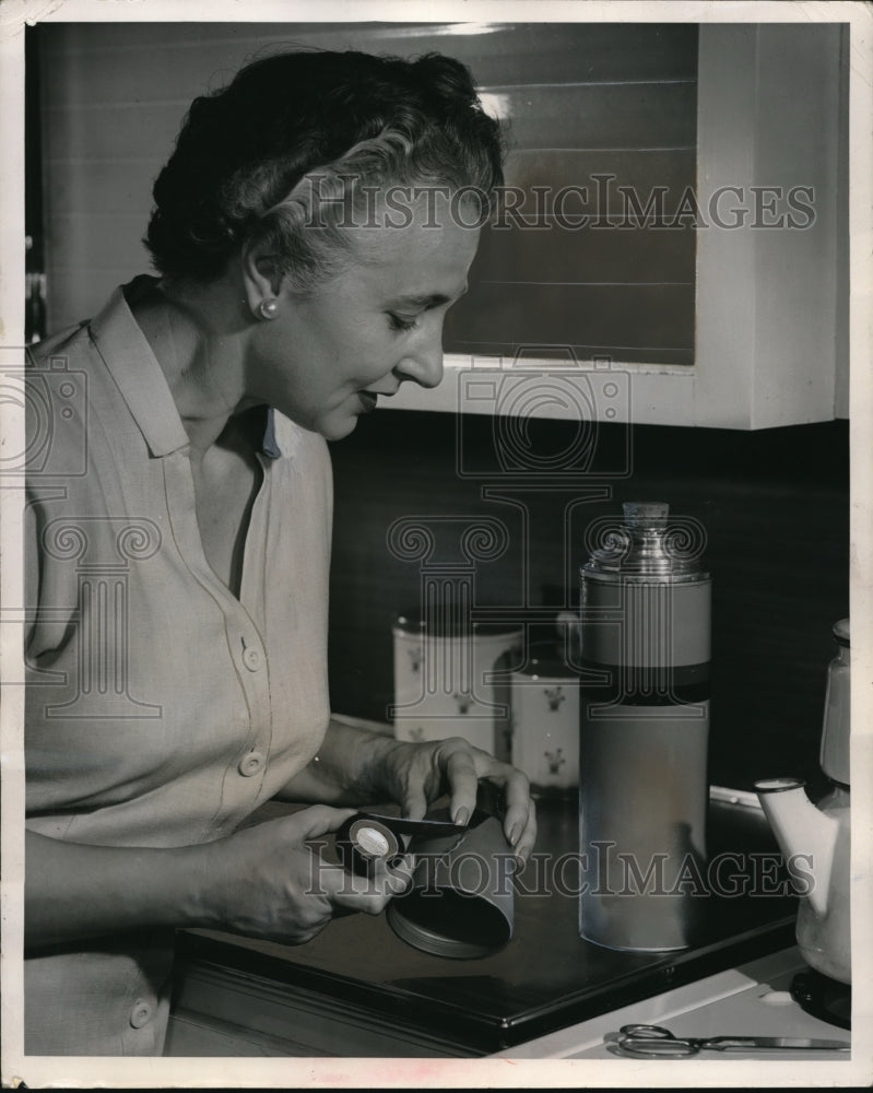 1952 A homemaker tapes up cracked of a thermos - Historic Images