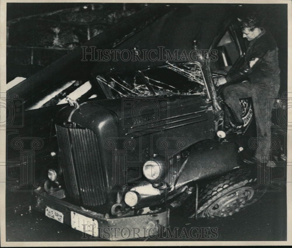 1947 Press Photo A man looking at the remains of the truck he wrecked earlier. - Historic Images