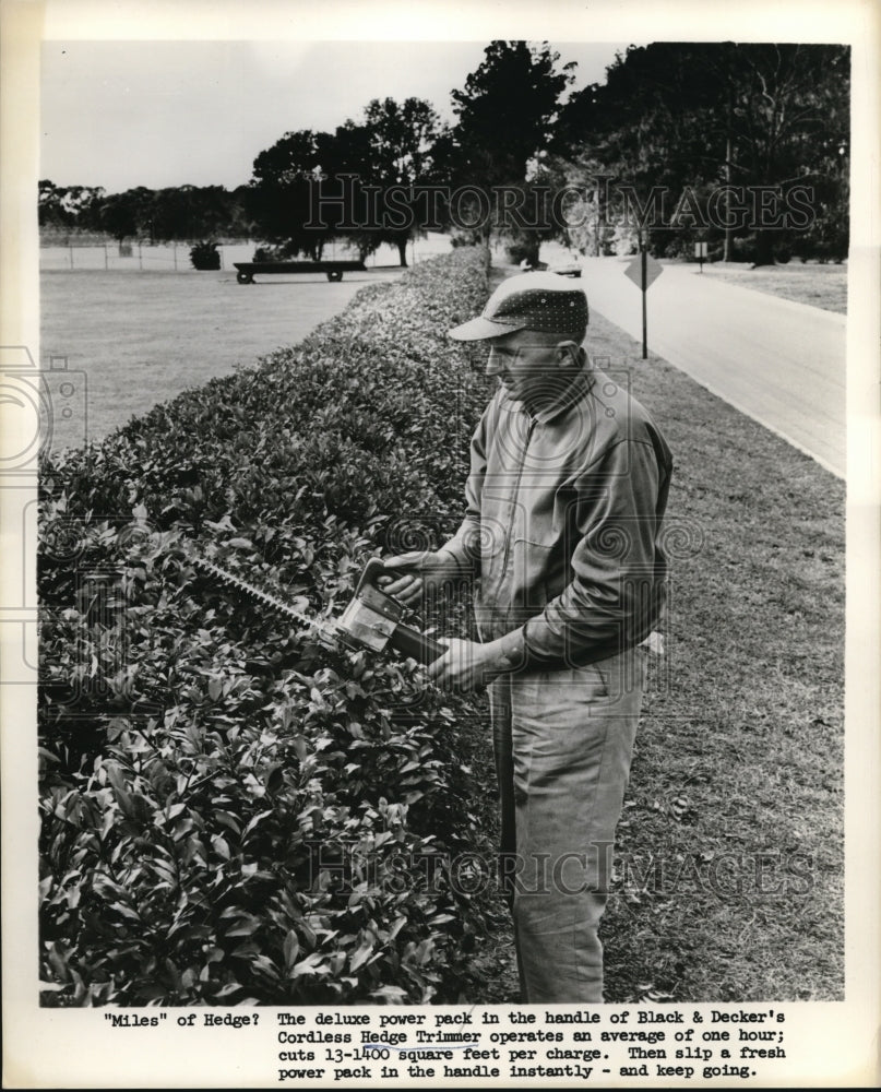 1962 Press Photo Black &amp; Decker cordless hedge trimmers &amp; battery pack in use - Historic Images