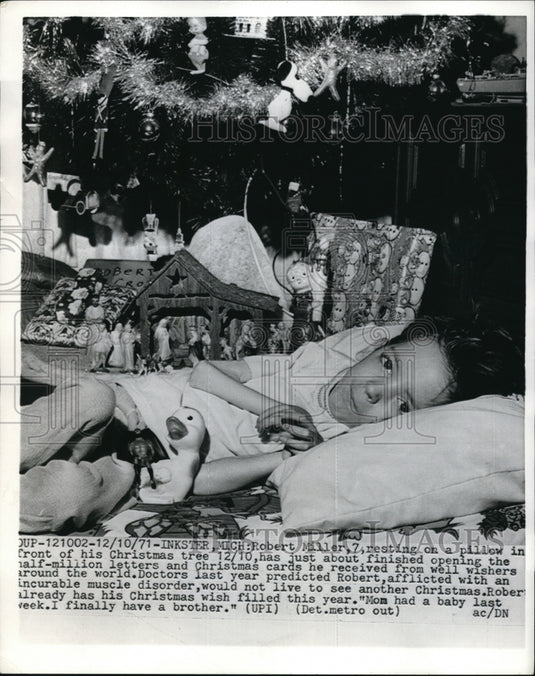 1971 Press Photo Robert Miller by his Christmas tree reading letters and cards - Historic Images