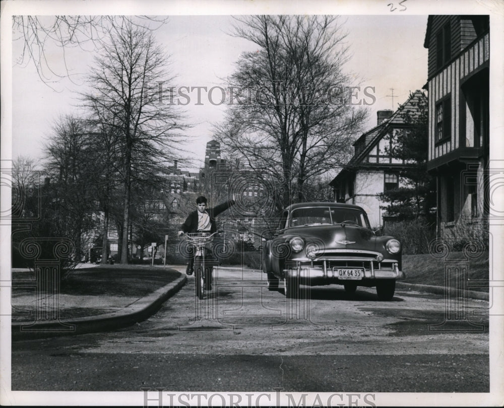 1951 The boy uses hand signal while he rides on his bicycle - Historic Images