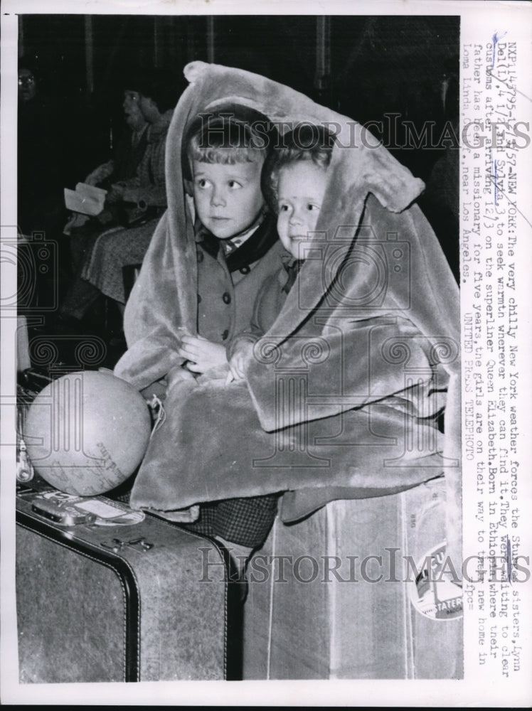 1957 Press Photo The Sturgas sisters seeking warmth before going to a new home - Historic Images