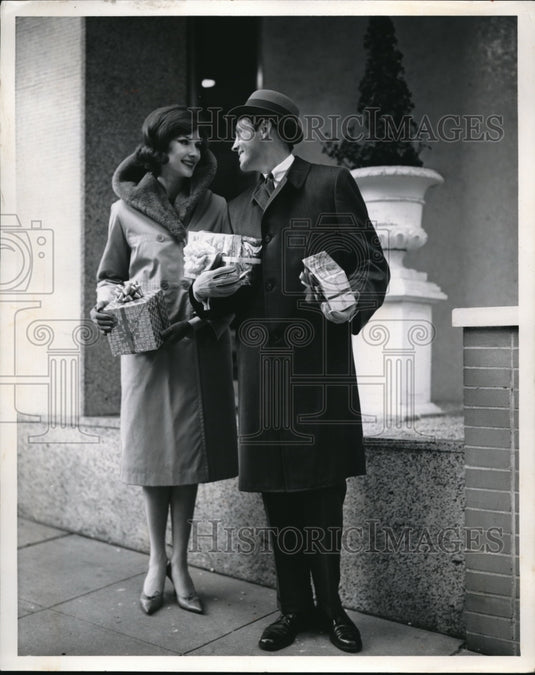 1962 Press Photo A man & woman with Christmas presents in hand - Historic Images