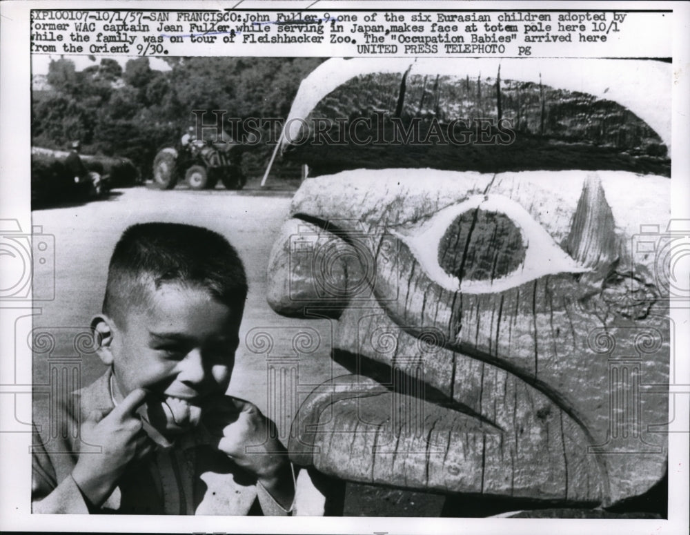 1957 Press Photo John Fuller makes a face at totem pole at Fleishhacker Zoo.-Historic Images