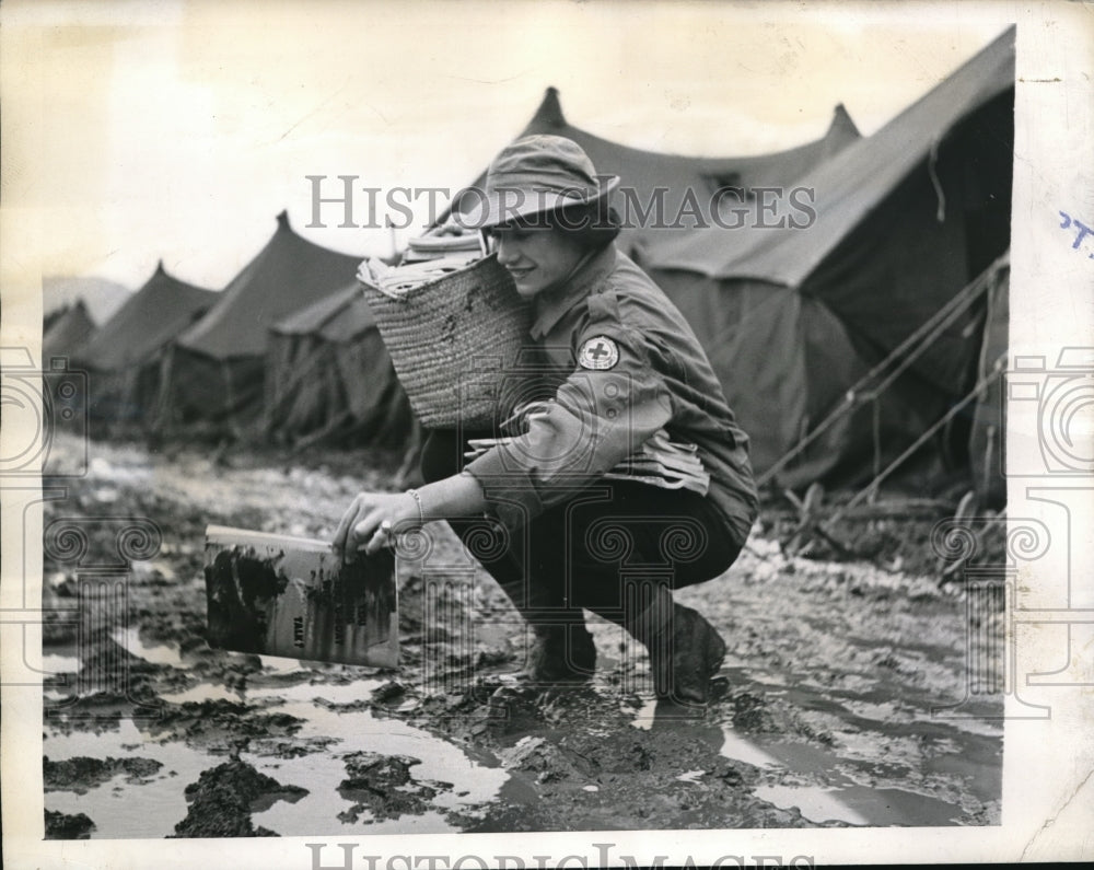 1943 Press Photo Nancy Gres Picks Up Mud Covered Magazine - Historic Images
