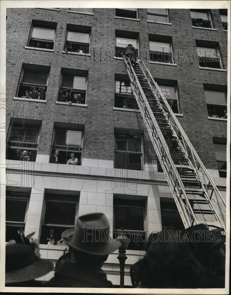 1942 Press Photo Fireman scales a ladder towards a building - Historic Images