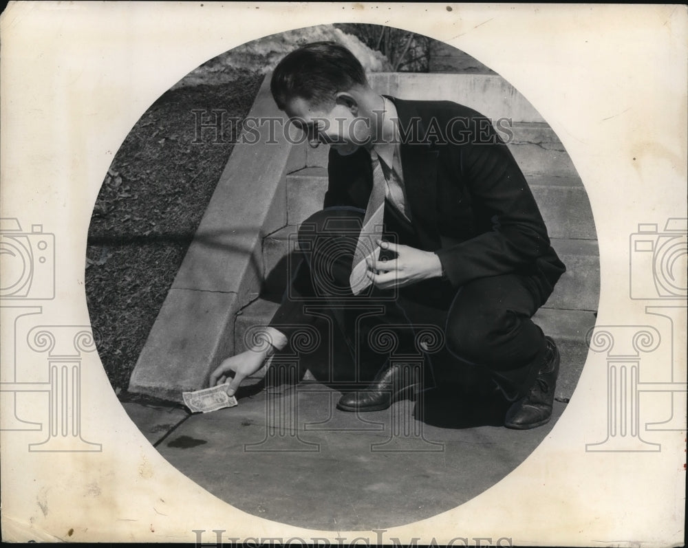 1940 Press Photo John Levin, Jr. picks up five dollar bill stage money - Historic Images