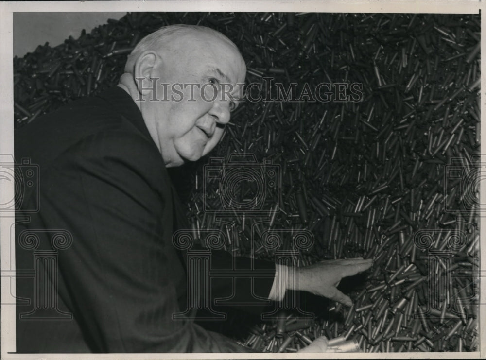 1944 Press Photo P.J. Haggerty examines stacks of shell and rifle bullet casings - Historic Images