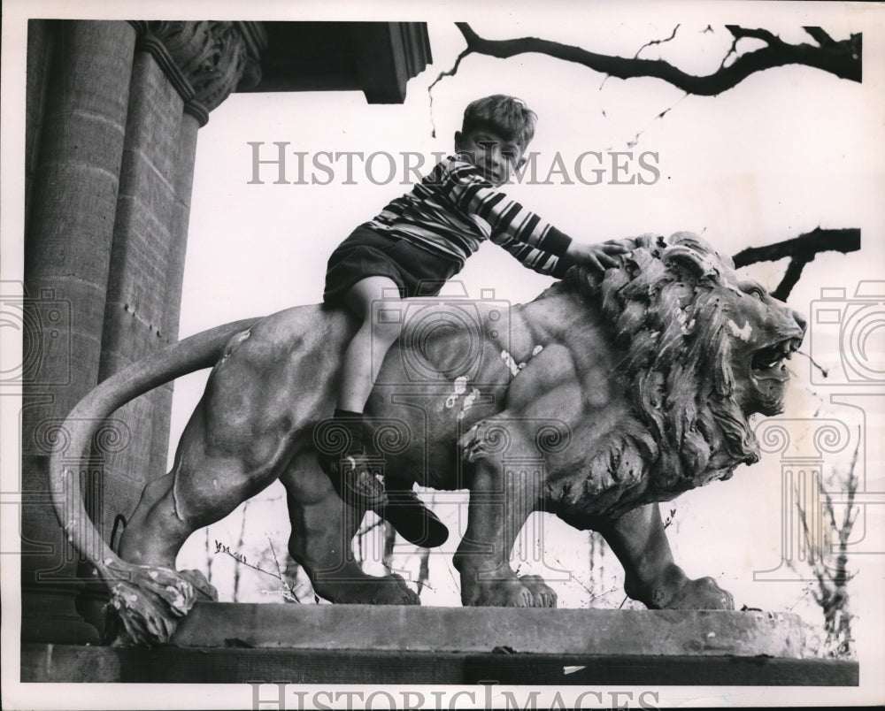 1951 Press Photo Marco Polo Schweter riding a stone lion - Historic Images