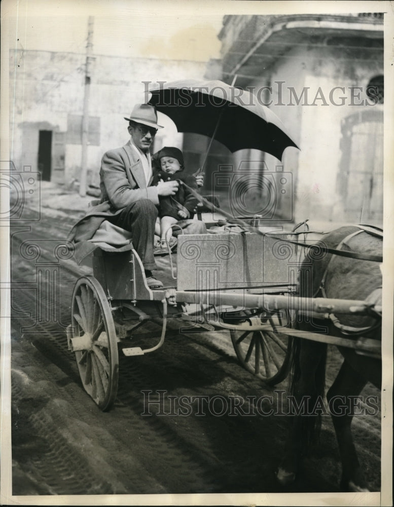 1944 Press Photo A man on a horse drawn cart protecting his child - ned42605-Historic Images