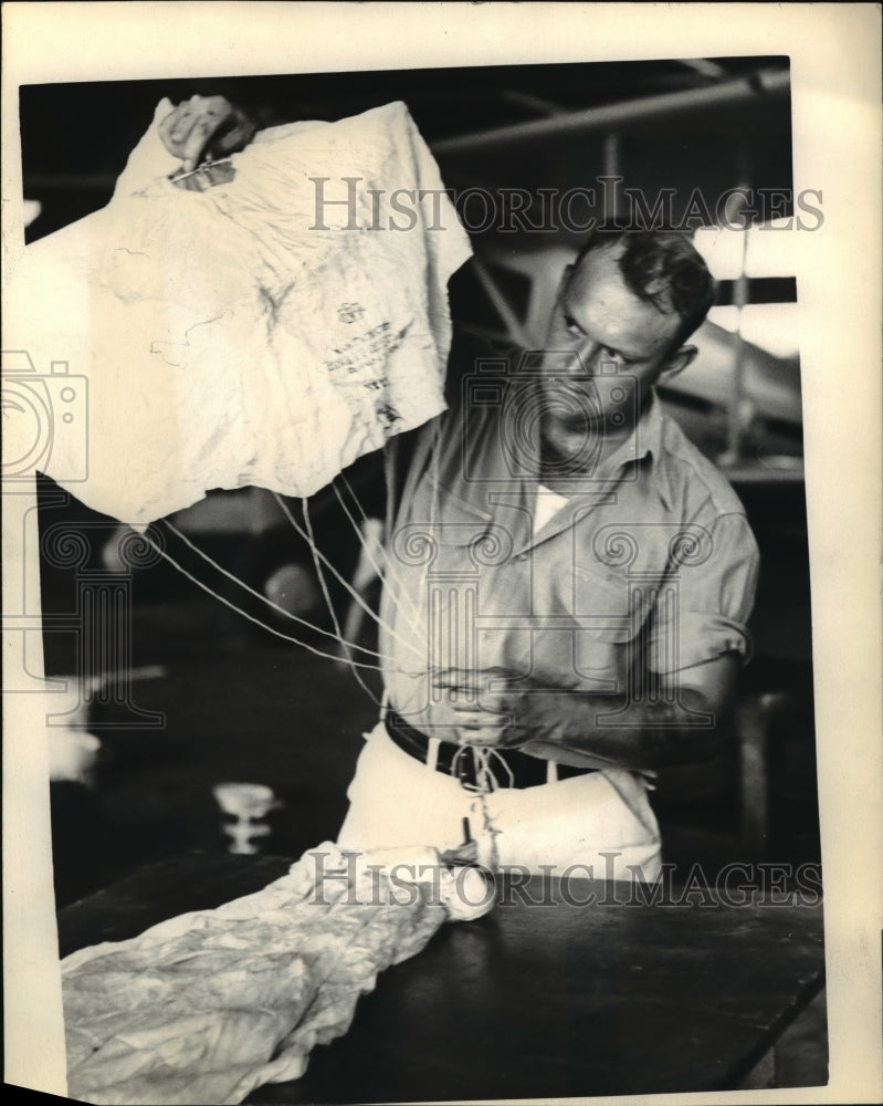 1937 Nary Souell packing one of his parachutes he is exhibiting the - Historic Images
