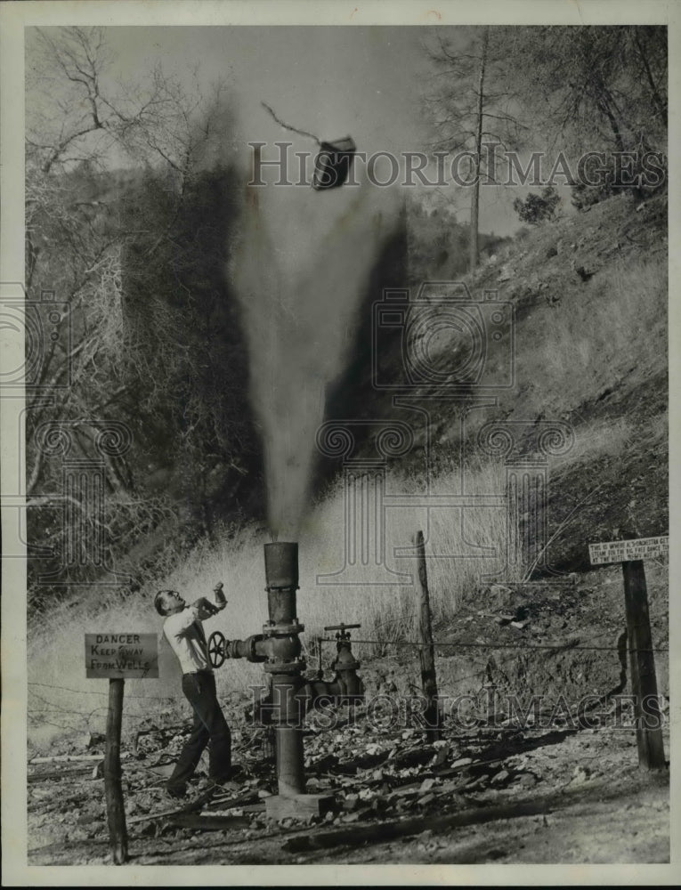 1933 Press Photo Man prepares kindling wood by letting gayser break up the boxes - Historic Images