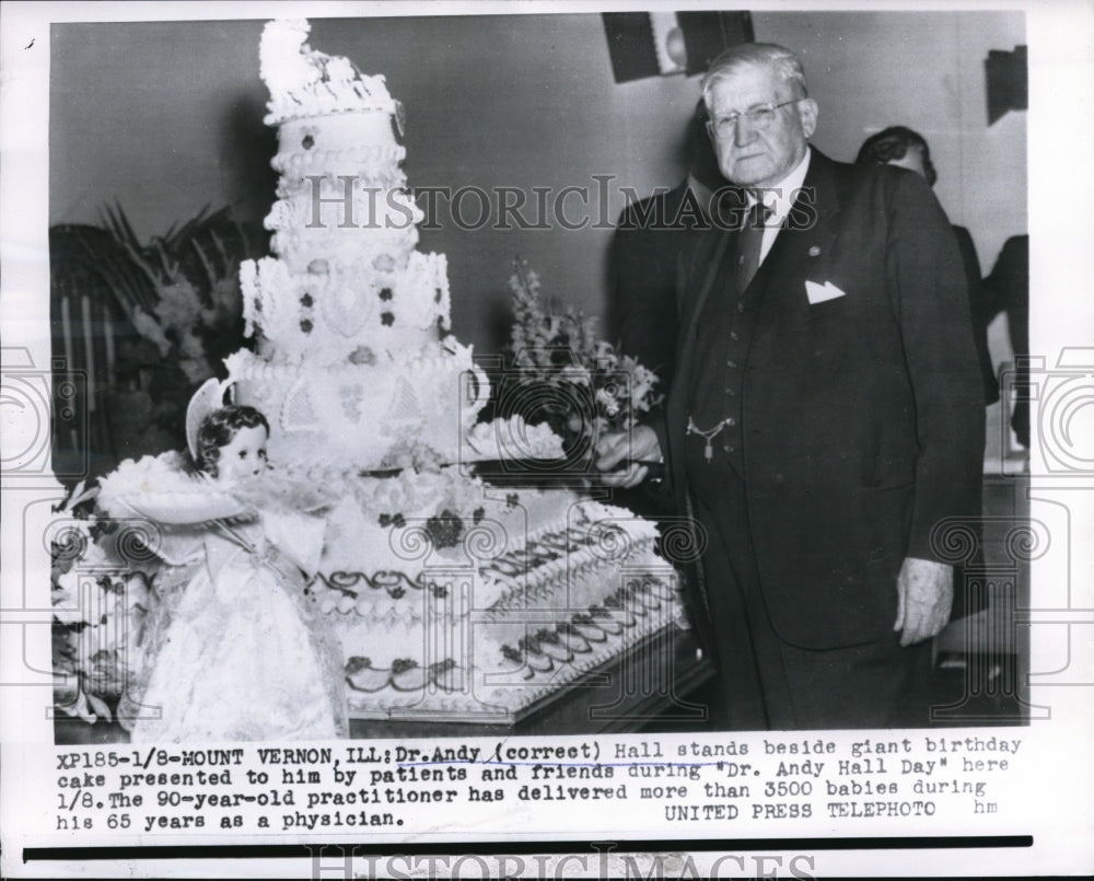 Dr. Andy Hall stands next to a birthday cake presented to him. - Historic Images