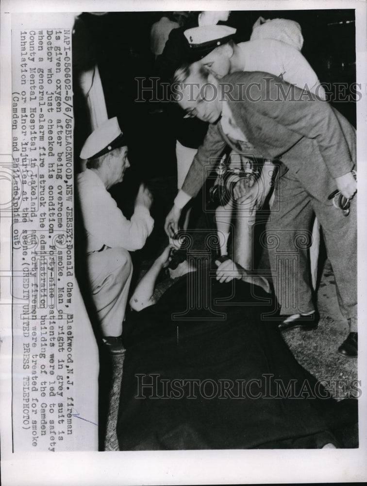 1956 Press Photo Donal Crew, firemen given oxygen after being overcpme by smoke - Historic Images