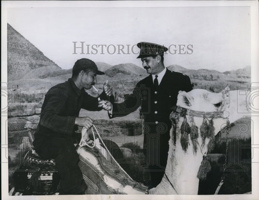 1955 Press Photo Prisoner on a camel gets a light from a guard during a picnic - Historic Images