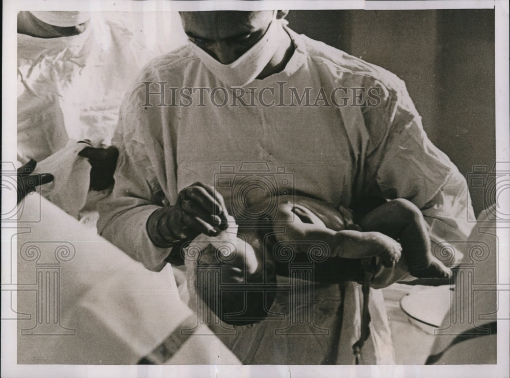 1938 Press Photo Doctor Clearing Mucus from Newborn Infant Baby&#39;s Throat-Historic Images