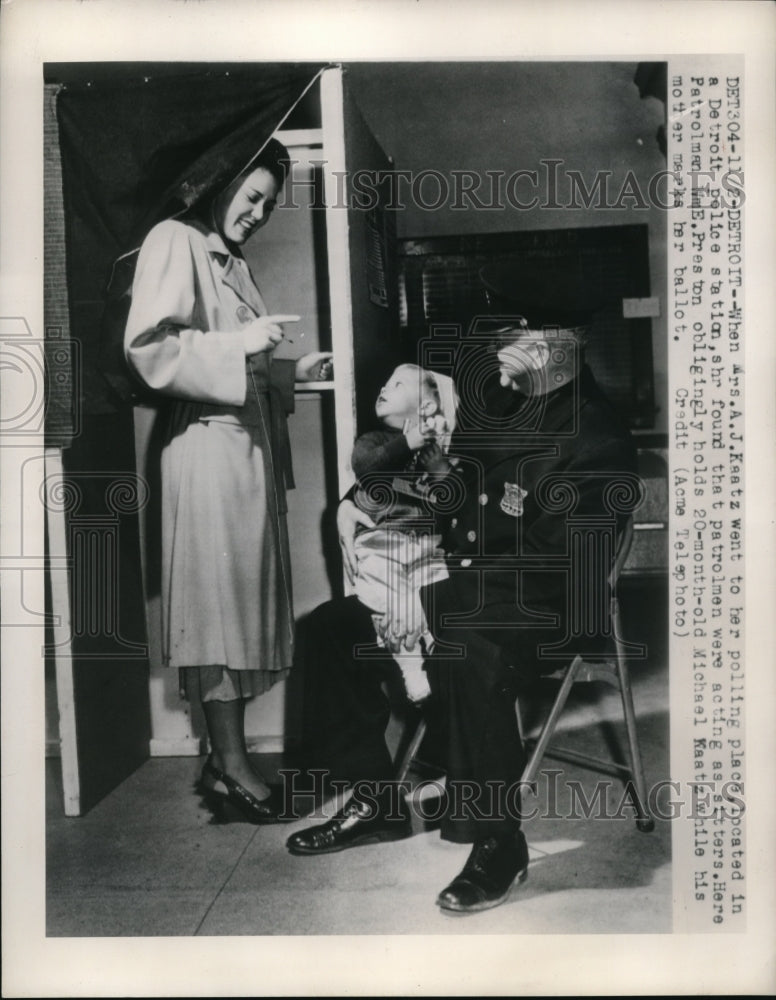 1948 Press Photo Mrs.A.J.Keatz in Polling Place while policeman baby sit her kid - Historic Images