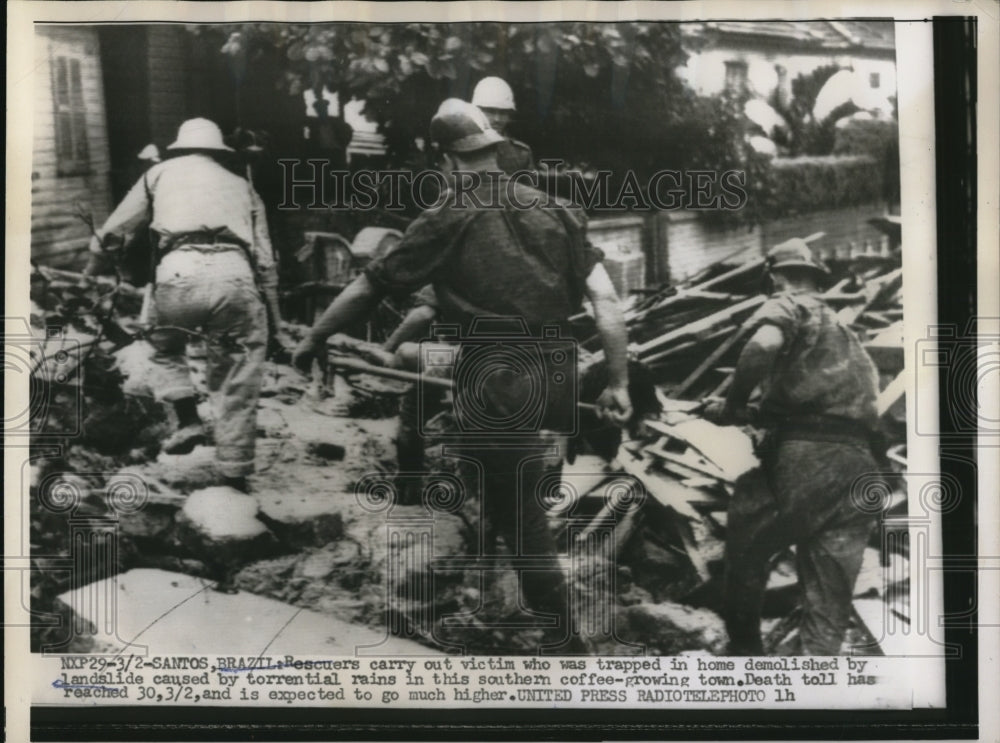 1956 Press Photo Rescuers carrying out the victim of the landslide - Historic Images