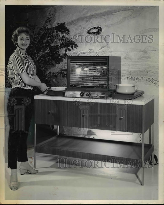 1959 Woman testing a Hotpoint, an electric countertop oven-Historic Images