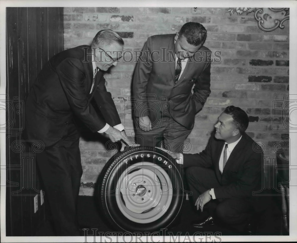 1964 Press Photo Frank Lesser examines a Firestone Indianapolis tire like the - Historic Images