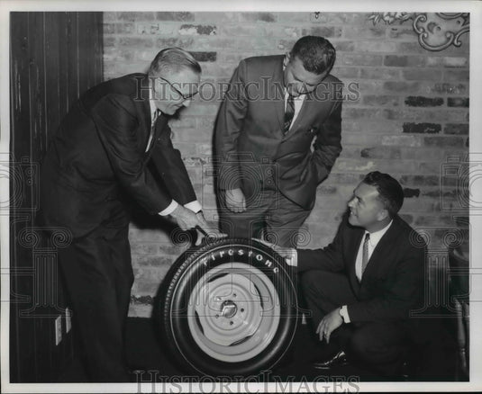 1964 Press Photo Frank Lesser examines a Firestone Indianapolis tire like the - Historic Images