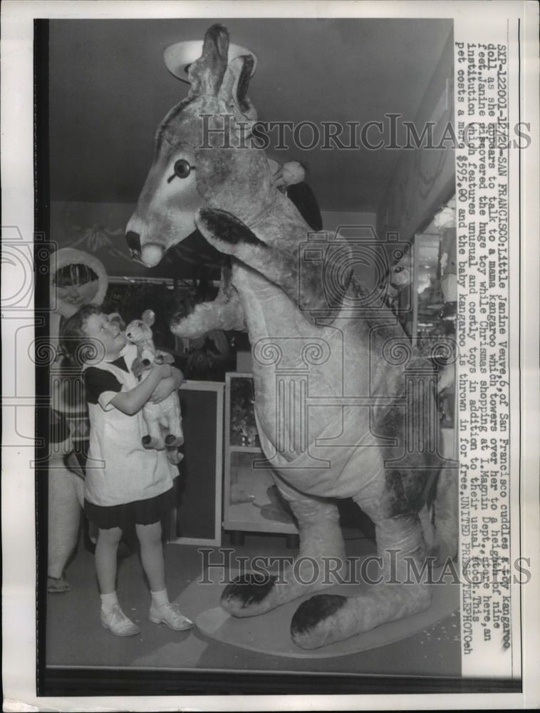 1957 Press Photo Janine Veuve holds on to a tiny kangaroo  at Magnin Dept store - Historic Images