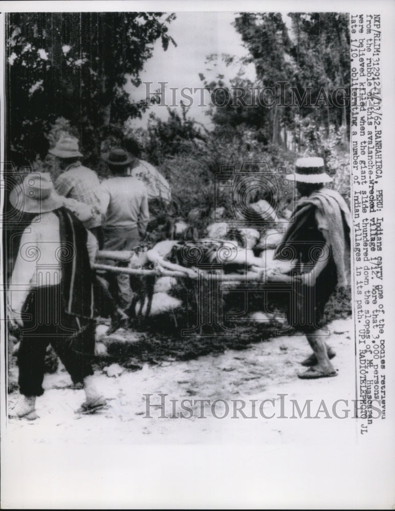 1962 Press Photo of Man carrying one of the bodies retrieved from rubble of an - Historic Images