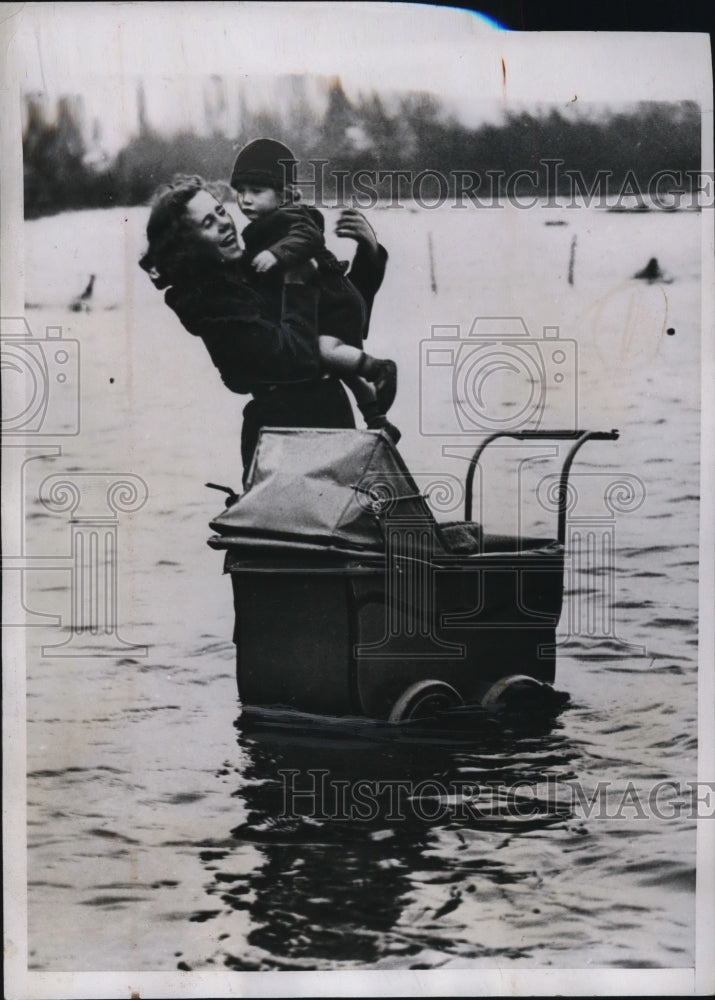 1935 Press Photo Mother Rescuing Child from Stroller During Flooding, England - Historic Images