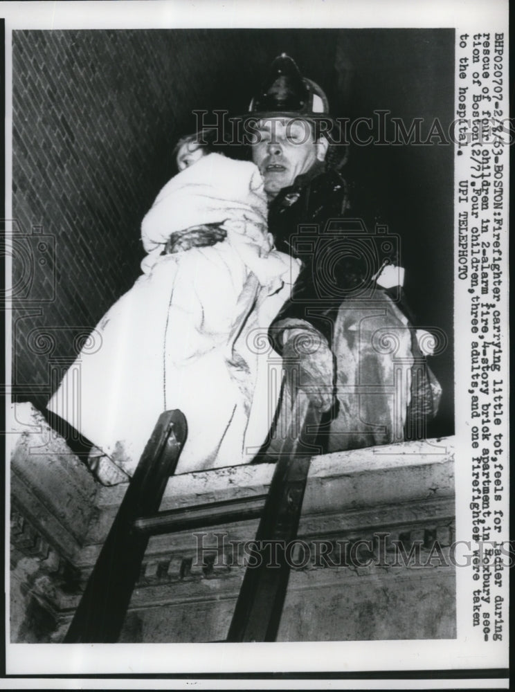 1963 Press Photo A fireman carries a little tot from the burning house - Historic Images