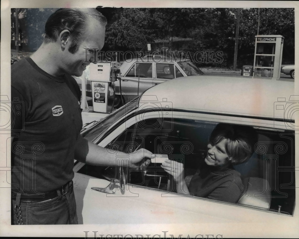 1969 Press Photo Patt Ott hand over her Texaco Cradit Card to Texaco Station. - Historic Images