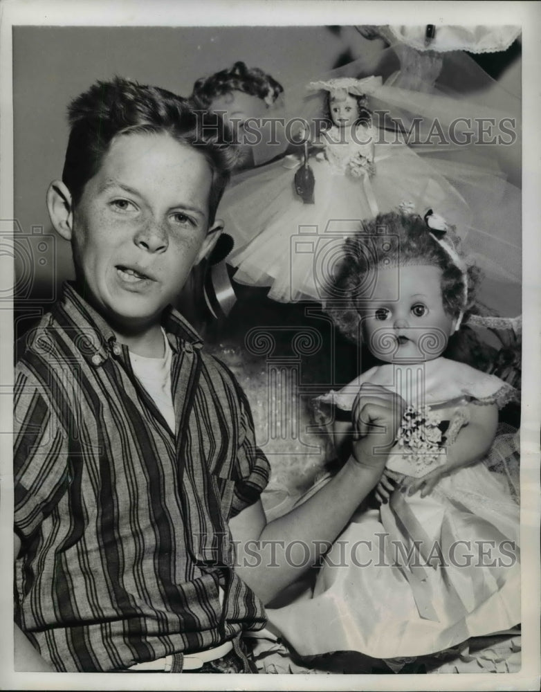1958 Press Photo Gary Oyen gestures disdainfully at the dolls - Historic Images