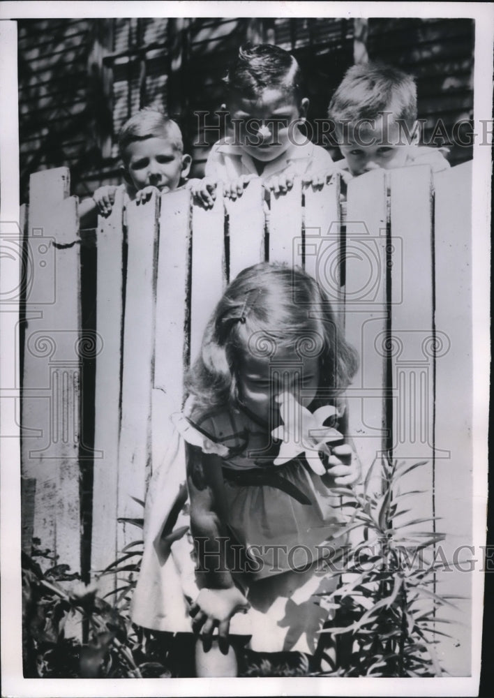 1954 Press Photo Patricia Krupnow, wrinkles her nose as she sniffs  Easter Lily - Historic Images